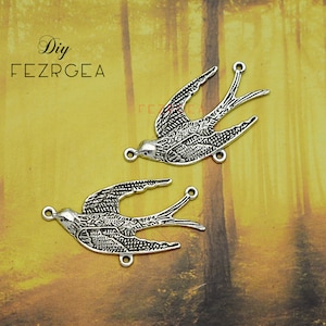 May include: Two silver-toned metal bird charms with detailed designs. Each charm has a loop at the top for attaching to jewelry or other crafts.