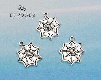 May include: Three silver-coloured spider web charms with a spider in the centre. Each charm has a small loop at the top for attaching to jewellery or other crafts. The charms are displayed on a light blue background.