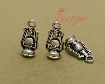 May include: Three silver-toned metal charms shaped like oil lamps. The charms have a loop at the top for attaching to a necklace or bracelet.