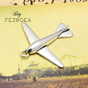 Peut inclure: Breloque d'avion en argent avec une boucle pour l'attacher à un collier ou un bracelet. Le charme mesure environ 5 cm de long.