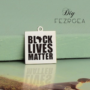 May include: A silver square charm with the words "Black Lives Matter" in black lettering and a black outline of the continent of Africa.