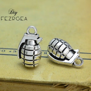 May include: Two silver-toned grenade charm pendants. The charms are detailed with a textured, ridged surface and a loop for attaching to a chain or bracelet.