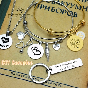 May include: A set of DIY jewelry making supplies featuring a silver charm bracelet with a stethoscope, a heart, a syringe, and a nurse's cap charm. The bracelet is paired with a gold charm bracelet with a heart and the text "Best Dad Ever". A silver key chain with the text "Merry Christmas, Dad I Love You" is also included.