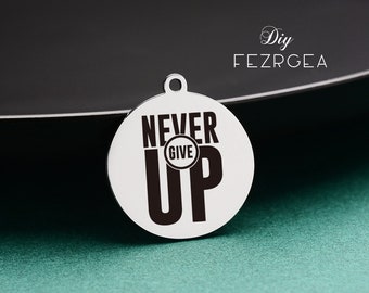 May include: A silver charm with the words "Never Give Up" in black lettering. The charm has a small loop at the top for attaching to a bracelet or necklace.