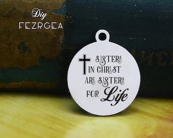 May include: A silver charm with a cross and the text "Sisters in Christ are sisters for life".