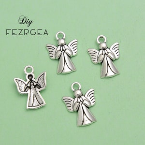 May include: Four silver-colored angel charms with outstretched wings and clasped hands. Each charm has a small loop at the top for attaching to jewelry or other crafts. The background is a light green color.