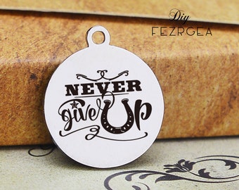 May include: Round silver charm with the words "Never give up" in black lettering and a horseshoe graphic.