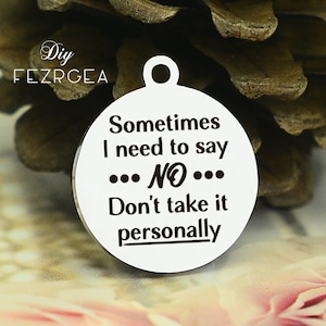 May include: A round silver charm with the text "Sometimes I need to say ... NO ... Don't take it personally" engraved on it.