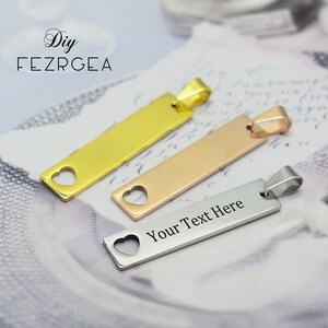 May include: Three rectangular pendants in gold, rose gold, and silver. Each pendant has a heart-shaped cutout and a loop for a chain. The silver pendant has the text "Your Text Here".