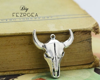 May include: Silver-toned metal bull skull charm pendant with a detailed design. The charm is hanging from a book with the text "DIY FEZRGEA" on the cover.