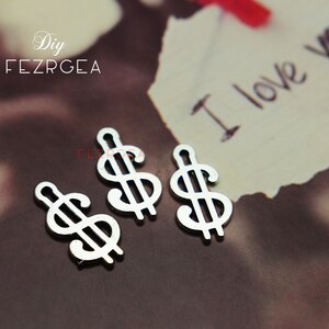 May include: Three silver dollar sign charms. The charms are on a white background with the words "I love you" written on it.