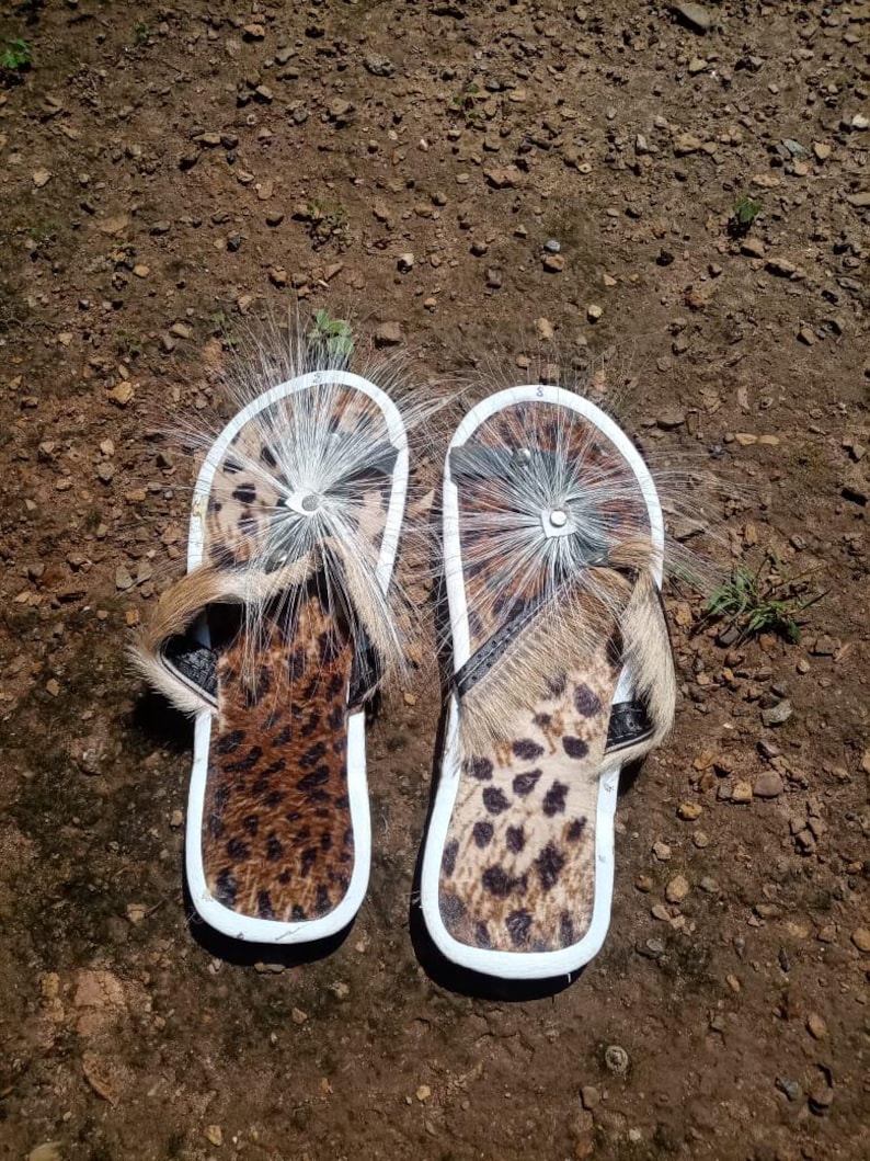 Brown Zulu Imbadada sandals made of genuine springbok hide with leopard print fabric insoles and tyre soles, photographed on a neutral background