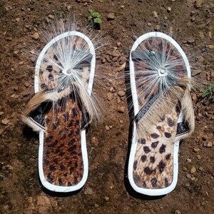 Brown Zulu Imbadada sandals made of genuine springbok hide with leopard print fabric insoles and tyre soles, photographed on a neutral background