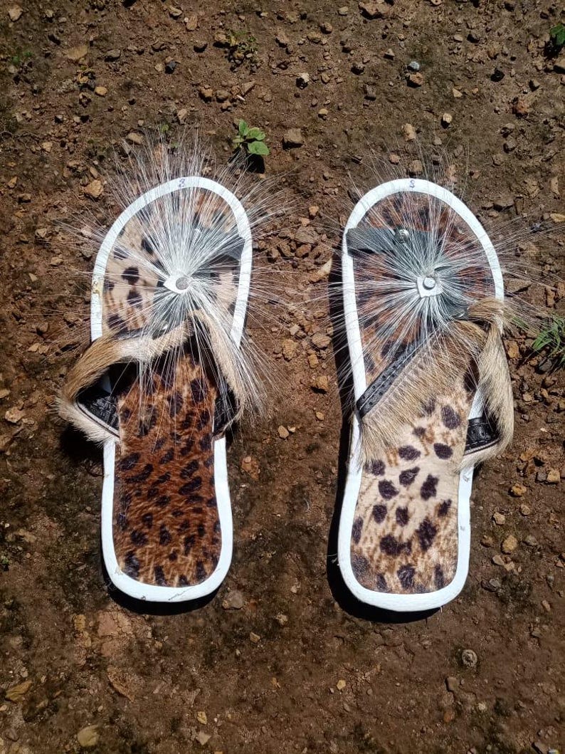 Brown Zulu Imbadada sandals made of genuine springbok hide with leopard print fabric insoles and tyre soles, photographed on a neutral background