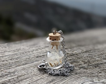 Small glass bottle with dandelions