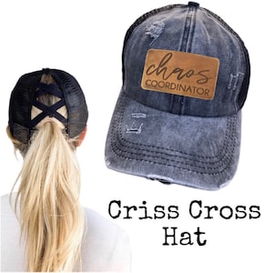 May include: A black criss-cross ponytail hat with a brown leather patch that says "chaos coordinator".
