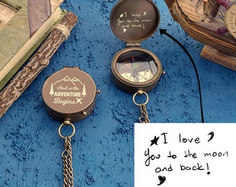 May include: Two antique brass compasses with chains. One compass has the inscription "And so the adventure begins" and the other has the inscription "I love you to the moon and back!"