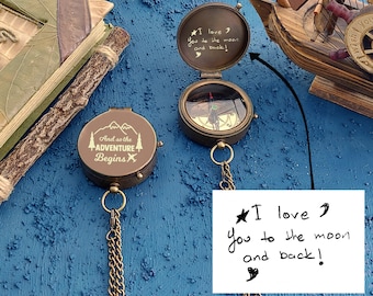 May include: Two antique brass compasses with chains. One compass has the inscription "And so the adventure begins" and the other has the inscription "I love you to the moon and back!"