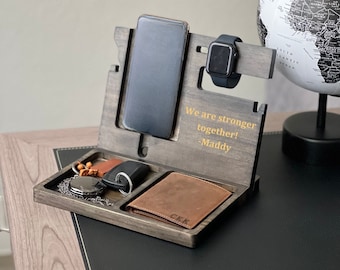 May include: A wooden phone stand with a watch holder, a small tray for keys and a wallet, and a personalized message that reads "We are stronger together! -Maddy".