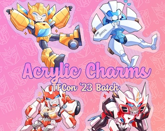 May include: Four colorful acrylic charms featuring Transformers characters. The characters are Bumblebee, Arcee, First Aid, and Chromia. The charms are labeled "TFCon '23 Batch" and "Acrylic Charms".