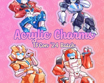 May include: Four colorful acrylic charms featuring Transformers characters. The characters are Optimus Prime, Bumblebee, Arcee, and Ironhide. The charms are part of the TFCon '24 Batch.