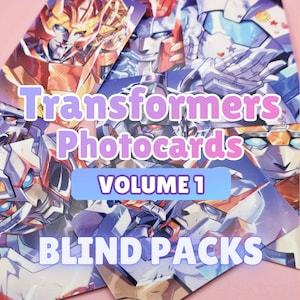 May include: A stack of Transformers Photocard blind packs. The cards feature colorful illustrations of Transformers characters. The text on the cards reads "Transformers Photocard Volume 1 Blind Packs" in a playful font, set against a pink background.
