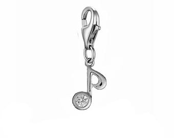 May include: Silver charm in the shape of a musical note with a clear rhinestone in the center. The charm has a lobster claw clasp.