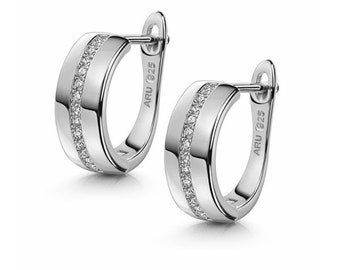 May include: Silver hoop earrings with a row of clear cubic zirconia stones around the edge. The earrings are marked "ARU 925" on the back.