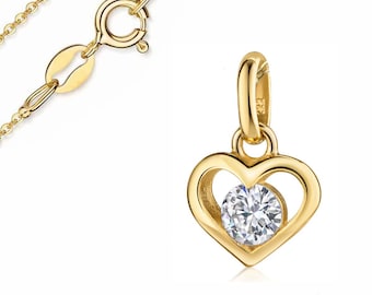 May include: A gold-colored heart-shaped pendant with a clear, round gemstone in the center. The pendant is attached to a delicate gold chain. The clasp and chain links are visible. The pendant is likely made of gold.
