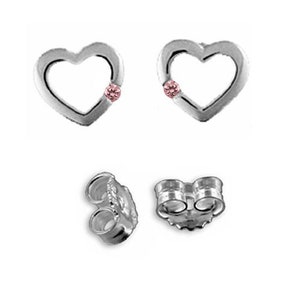 Puede incluir: Un par de pendientes de plata en forma de corazón con una pequeña piedra preciosa rosa en el centro de cada corazón.