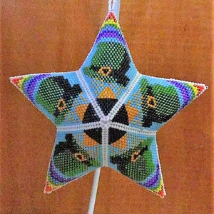 May include: A star-shaped ornament made of beads in shades of green, blue, white, yellow, and orange. The ornament features a repeating pattern of leprechaun hats.