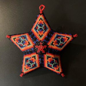 May include: A beaded star ornament with a geometric pattern in shades of red, orange, blue, green, and black.