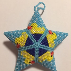 May include: A blue star-shaped ornament with white polka dots and yellow rubber duckies. The duckies have red beaks and black eyes.