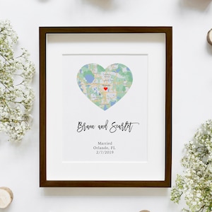 May include: A framed print with a heart-shaped map of Orlando, Florida. The text "Brain and Scarlet" is written in cursive below the map. The text "Married Orlando, FL 2/7/2019" is written below the names.