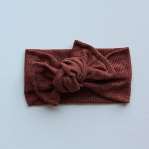 May include: A brown ribbed knotted headband with a subtle sparkle.