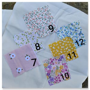 May include: A collection of 10 fabric swatches with floral patterns. The swatches are numbered 7 through 12. The swatches are arranged in a semi-circle on a white surface.