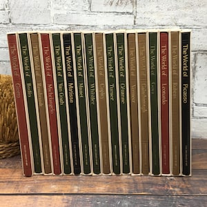 May include: A set of 18 hardcover books with gold lettering on the spines. The books are titled "The World of" followed by the name of an artist, such as "The World of Picasso" and "The World of Rembrandt".