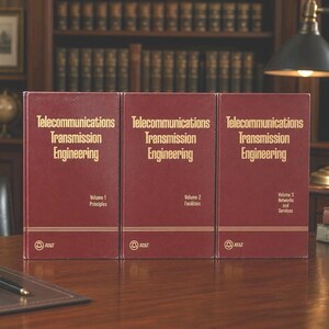May include: Three maroon hardcover books titled Telecommunications Transmission Engineering, labeled Volume 1 Principles, Volume 2 Facilities, and Volume 3 Networks and Services. Each book features gold text and the AT&T bell logo at the bottom.