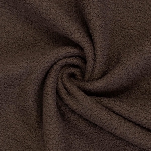 Könnte beinhalten: Ein dunkelbrauner Stoff mit einer dichten, strukturierten und lockigen Oberfläche. Das Material ist in einer zentralen Spirale angeordnet, die die Tiefe und die gleichmäßige dunkelbraune Farbe des flauschigen, fleeceartigen Textils zeigt.
