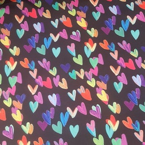 May include: Black fabric with a colourful, hand-drawn heart pattern. The hearts are in various shades of pink, purple, blue, green, yellow, and orange.