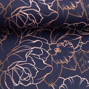 Könnte beinhalten: Ein marineblauer Stoff mit einem sich wiederholenden Muster aus goldenen und rosafarbenen Blumendesigns. Die Blumen sind in Gold umrandet und mit einer hellrosa Farbe gefüllt.