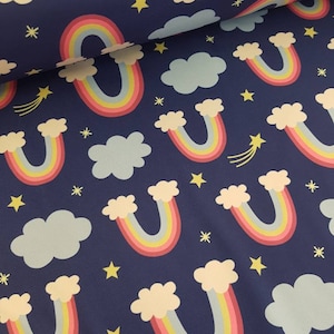 Könnte beinhalten: Marineblauer Stoff mit einem sich wiederholenden Muster aus bunten Regenbogen, weißen Wolken, gelben Sternen und Sternschnuppen. Die Regenbogen haben rosa, gelbe und blaue Bögen. Geeignet für Bastel- oder Nähprojekte.