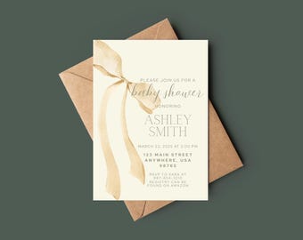 May include: Baby shower invitation featuring a cream-colored card with gold ribbon accents and text. The invitation is placed on top of a brown envelope. The text reads "Please join us for a baby shower honoring Ashley Smith."