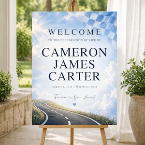 May include: A wooden easel displays a sign with the text "WELCOME TO THE CELEBRATION OF LIFE OF CAMERON JAMES CARTER". The sign includes dates, a road graphic, and the phrase "Forever in Our Hearts". The background is a sky with clouds.