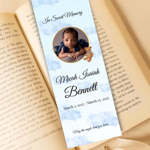 Puede incluir: Un marcapáginas conmemorativo con la foto de un bebé, el nombre "Micah Isaiah Bennett" y las fechas del 3 de marzo de 2025 al 25 de marzo de 2025. El diseño incluye un osito de peluche y un fondo de cielo azul nublado.