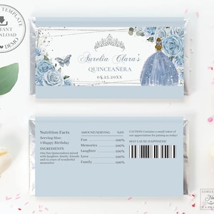 May include: A blue and white chocolate bar wrapper with a silver frame and a crown. The wrapper features a blue dress with a butterfly and the text "Aurelia Clara's Quinceañera 05.25.20XX".