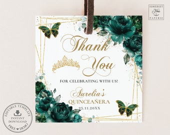 May include: Square white tag with gold geometric accents, emerald green floral arrangements, and gold butterflies. Text reads "Thank You" and "Aurelia's Quinceañera". Includes a gold tiara illustration and a brown ribbon.