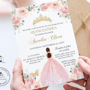 May include: A pink and gold Quincea&ntilde;era invitation with a floral design and a silhouette of a girl in a pink dress. The invitation includes the text "MR. & MRS. GARC&Iacute;A INVITE YOU TO CELEBRATE THE QUINCEA&Ntilde;ERA OF THEIR DAUGHTER Aurelia Clara SATURDAY, SEPTEMBER 23. 20XX 11 O'CLOCK ST. JOHN'S CHURCH 331 George Street Orlando FL Reception to follow AT 2:00PM EAST LAKE GOLF CLUB 1653 Taylor Oaks Drive Lawrenceville FL RSVP to Sophia. 256-456-8933 by July 15th"