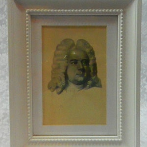 May include: A framed portrait of a man with a white wig and a serious expression. The portrait is in a white frame with a decorative border.