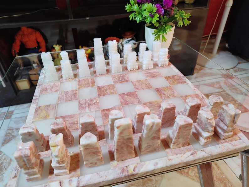 Pu&ograve; includere: Un set di scacchi in marmo bianco con scacchiera a scacchi rosa e bianca. I pezzi degli scacchi sono scolpiti in uno stile unico e la scacchiera &egrave; realizzata in un bellissimo marmo.